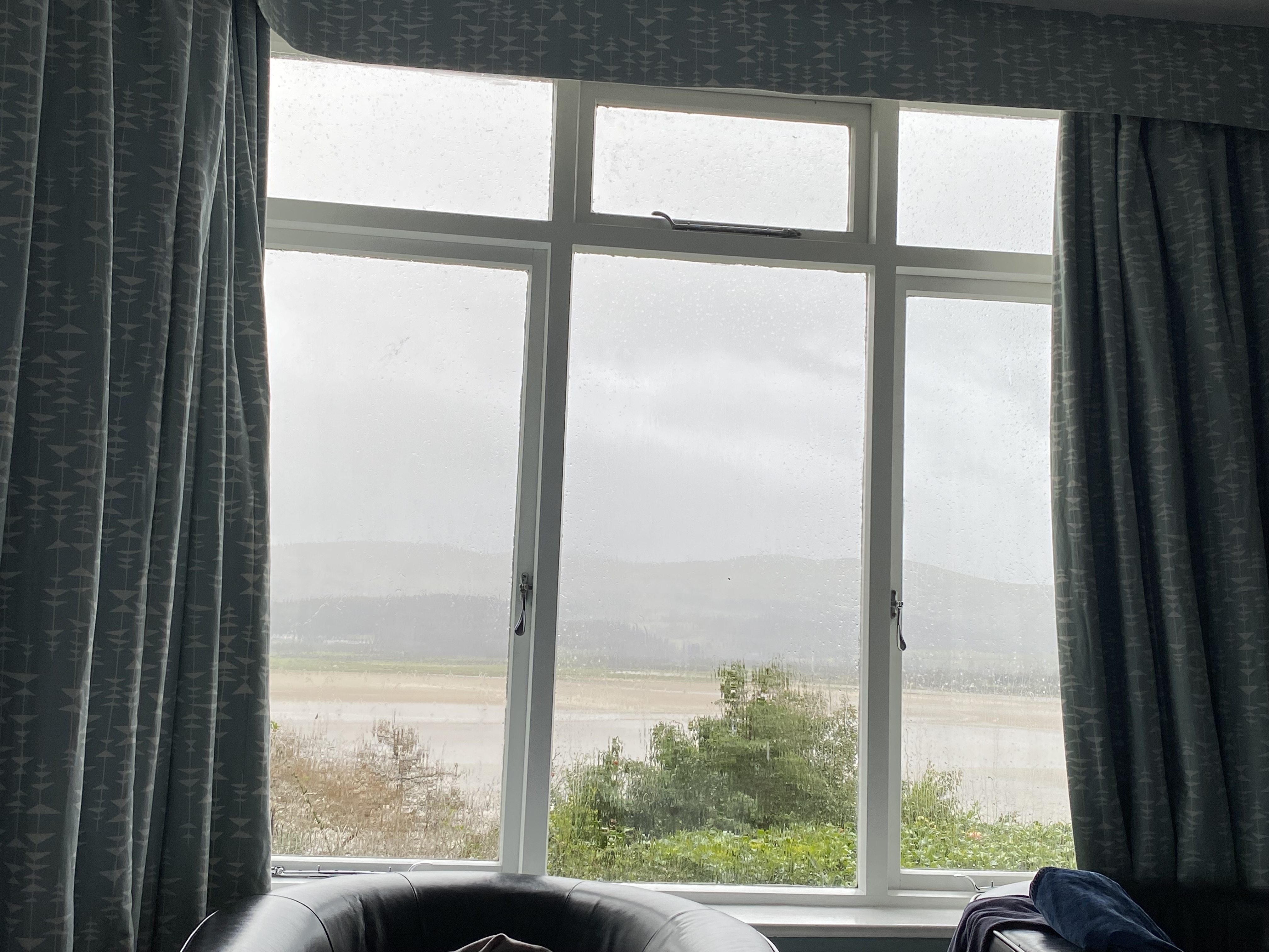 a window with a view of a lake and mountains