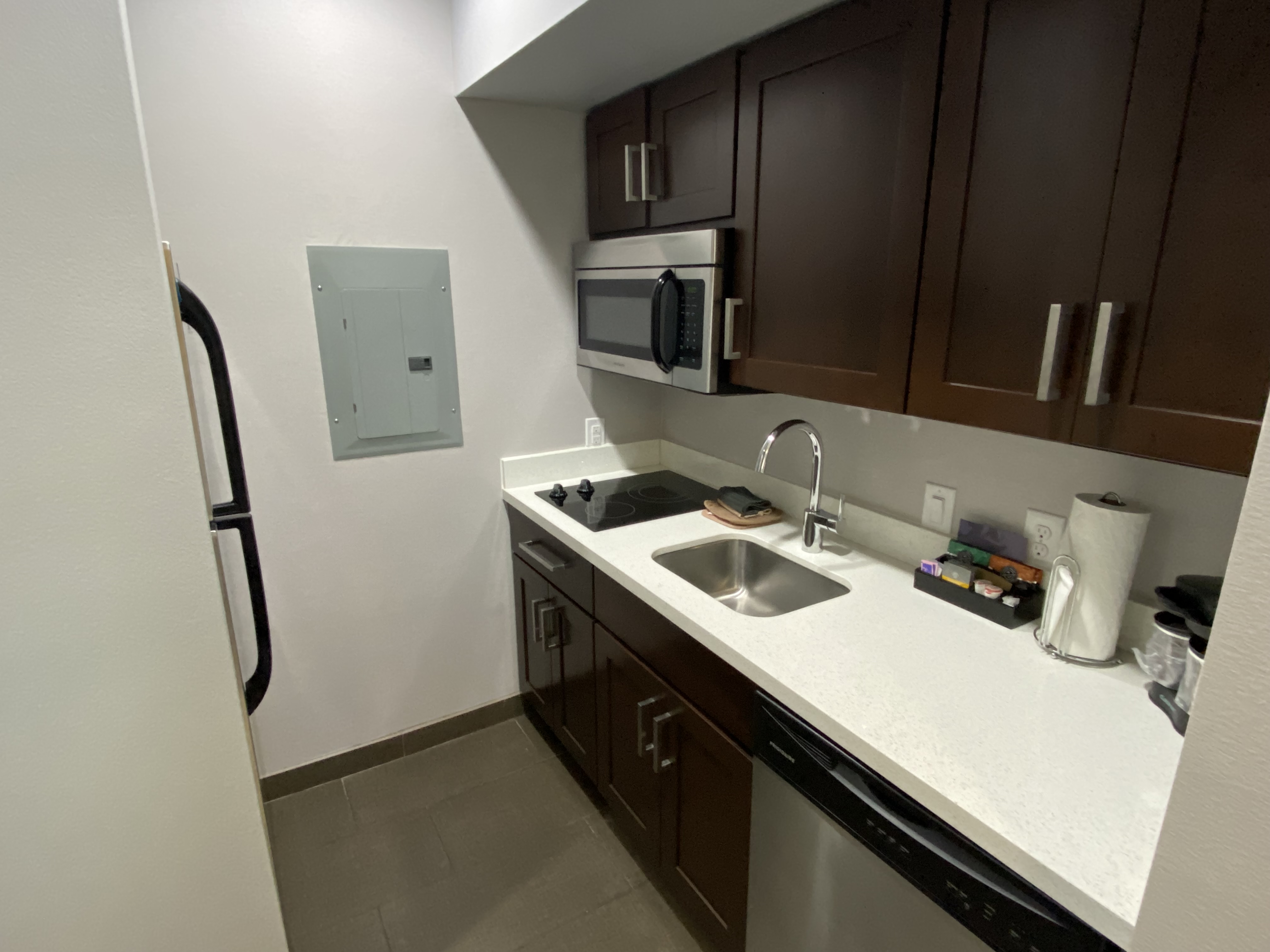 a kitchen with dark cabinets and a microwave