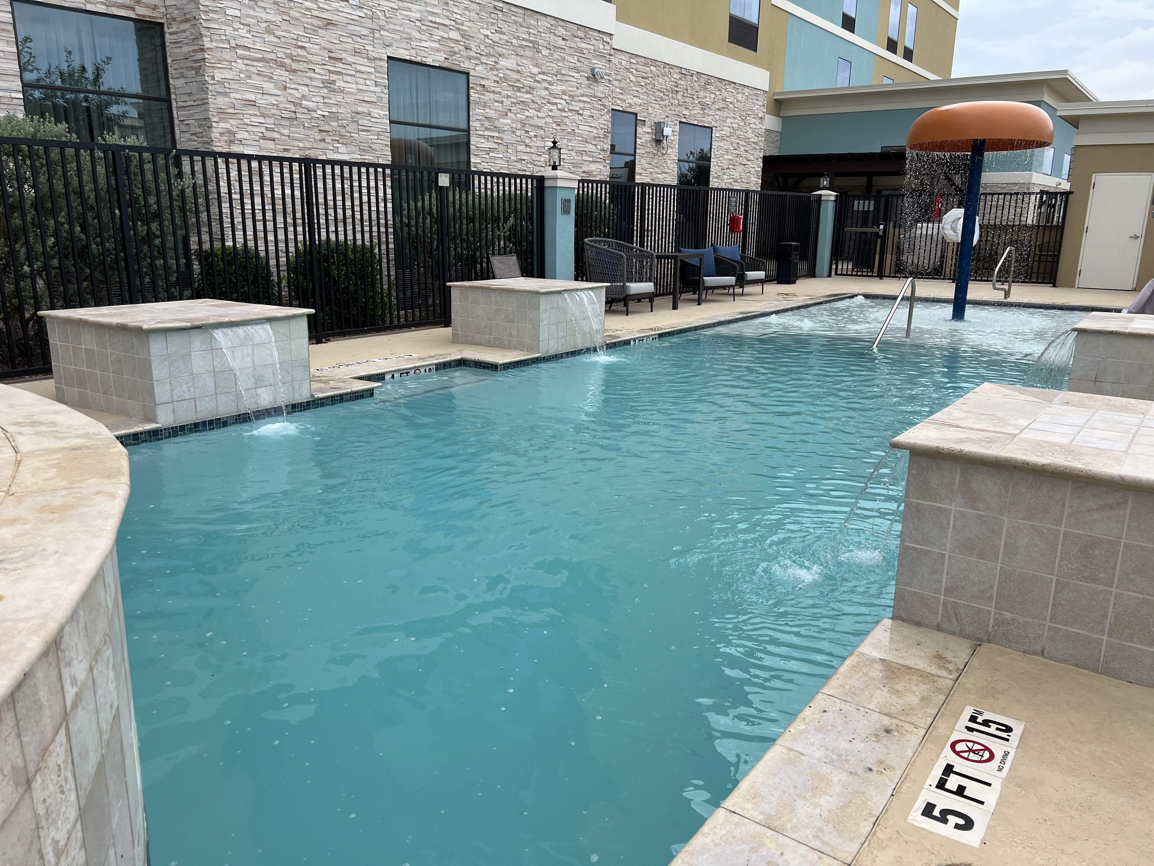 a swimming pool with a black fence and a building