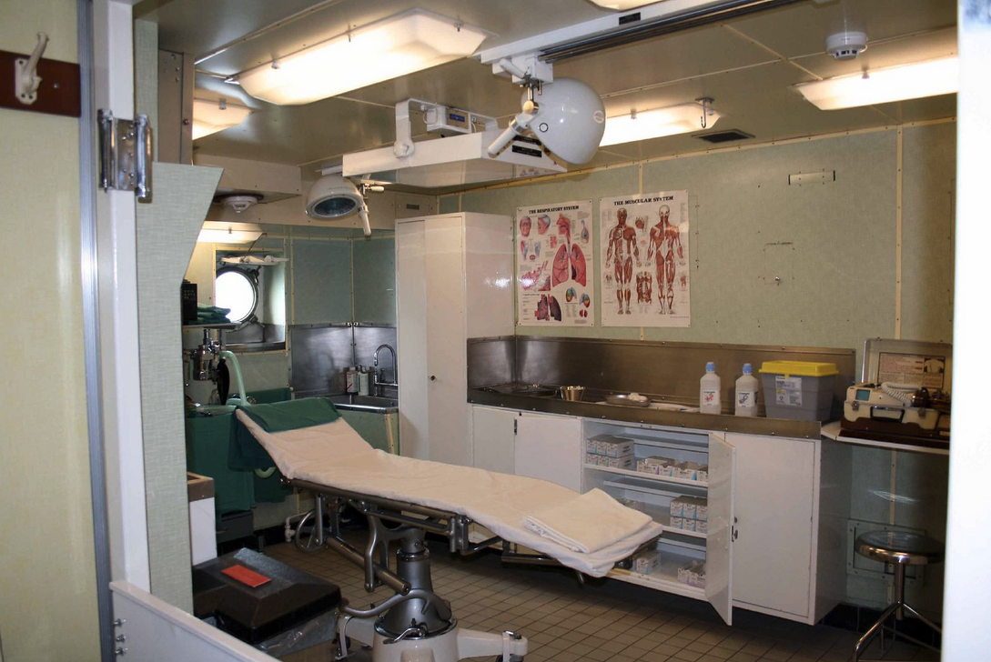 a room with a medical table and medical equipment