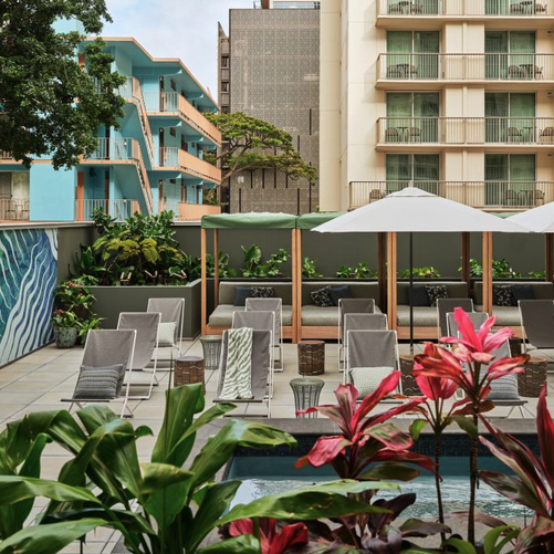 a pool with chairs and umbrellas in front of a building