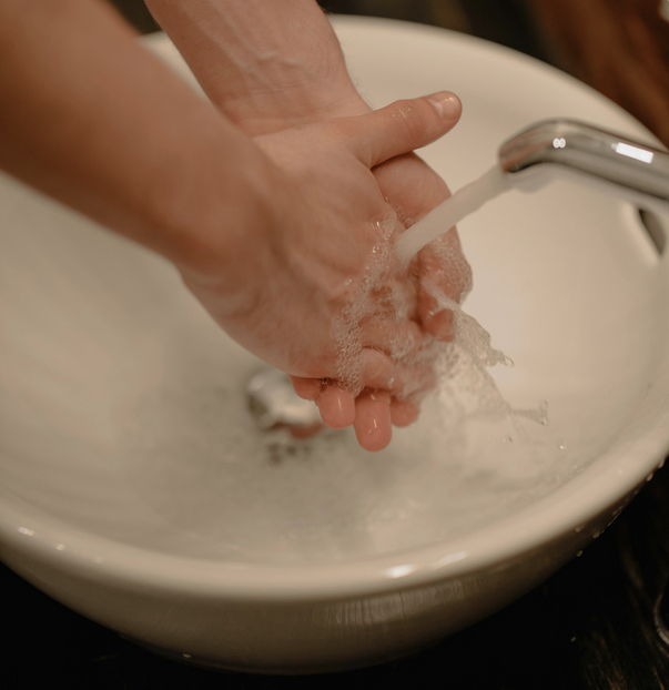 a person washing their hands in a sink