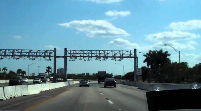 cars on a highway under a bridge