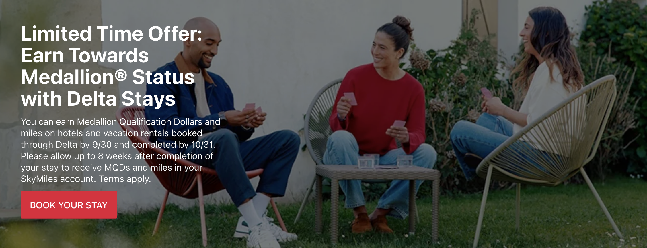 a man and woman sitting outside playing cards