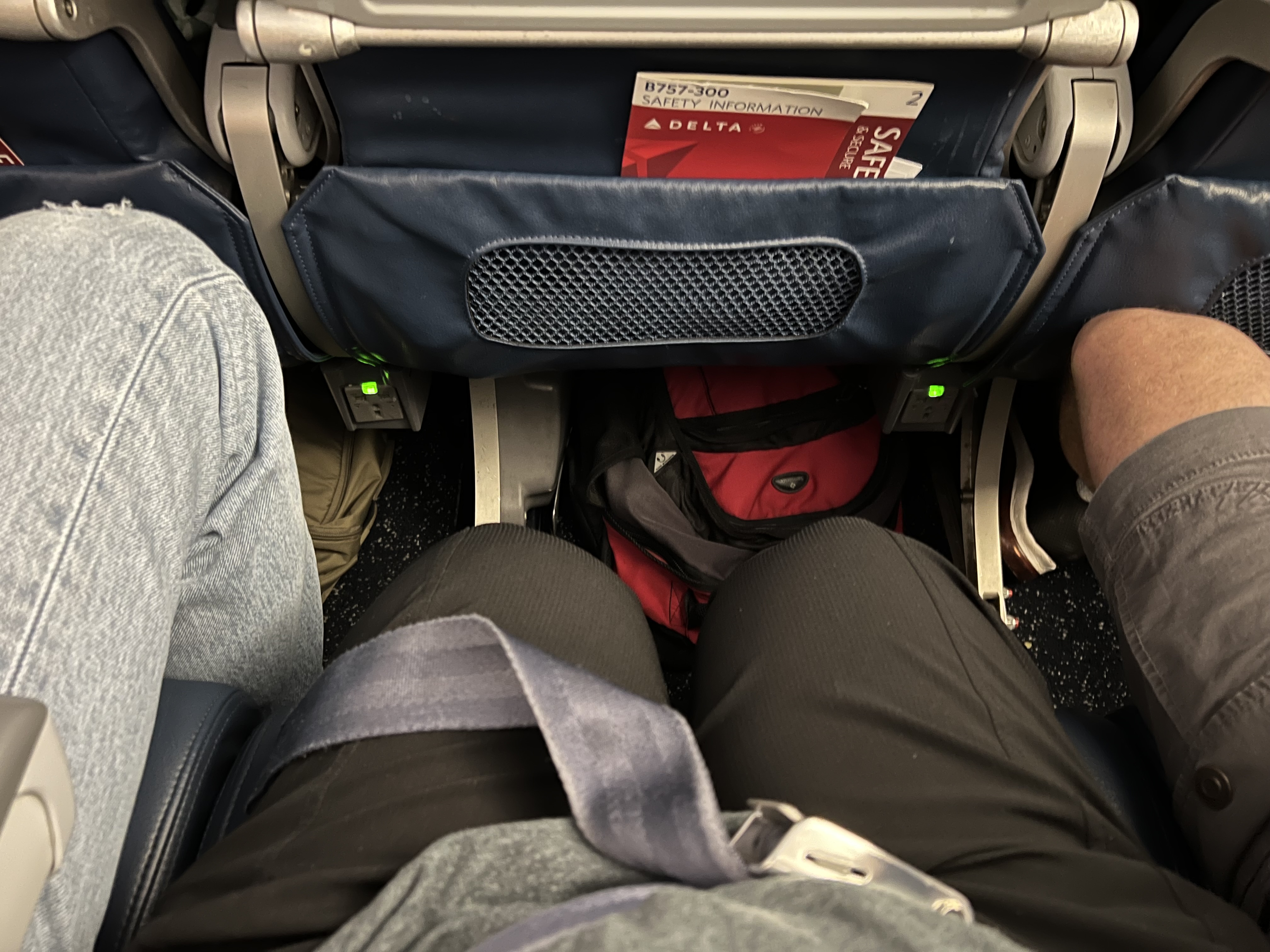 a person's legs in an airplane seat