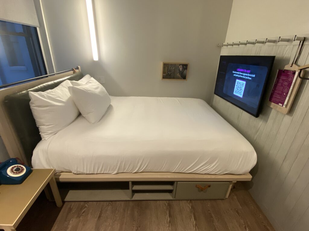 a bed with a tv on the wall