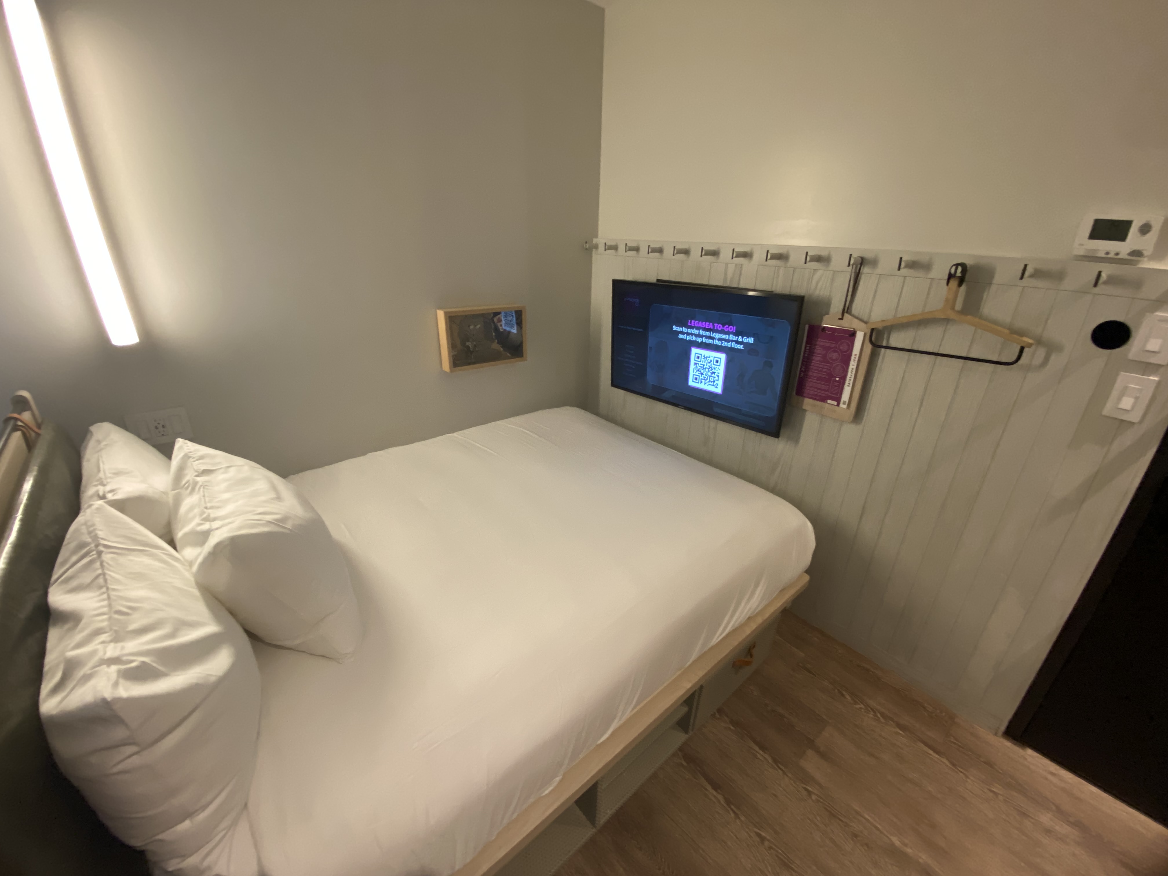 a bed with a tv mounted on the wall