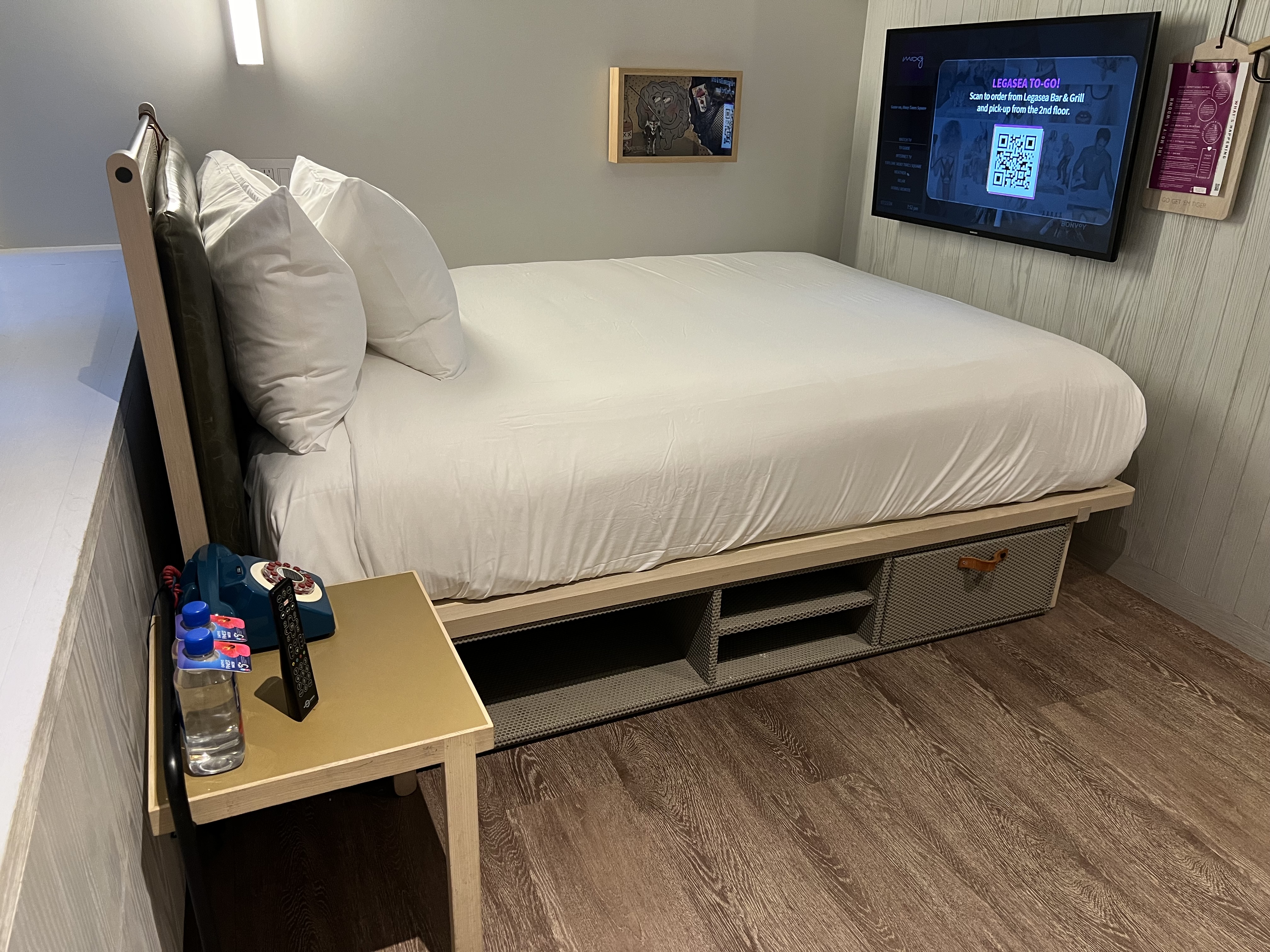 a bed with a tv on the wall