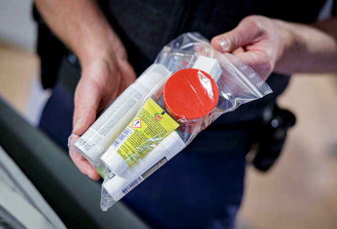 a person holding a plastic bag of travel items