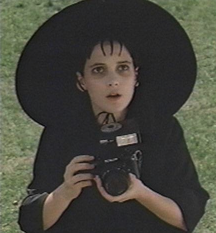 a woman in a hat holding a camera