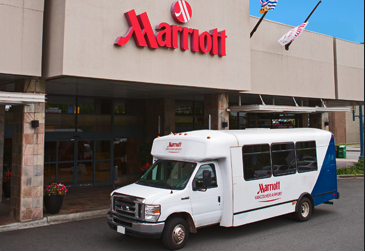 a white bus parked outside of a hotel