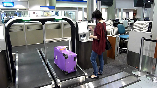 a woman standing at a luggage conveyor belt