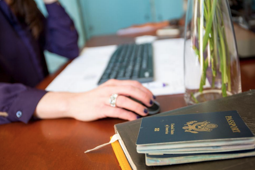 a hand on a mouse next to passport