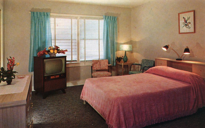 a bedroom with a pink bed and a television