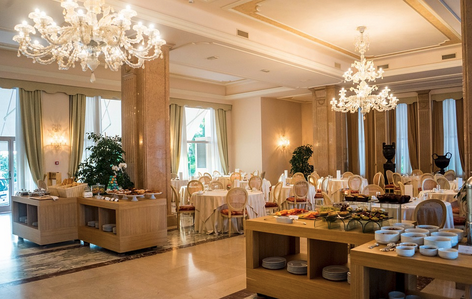 a room with tables and chairs and chandeliers