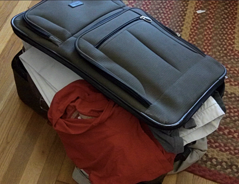 a suitcase with clothes on top of it