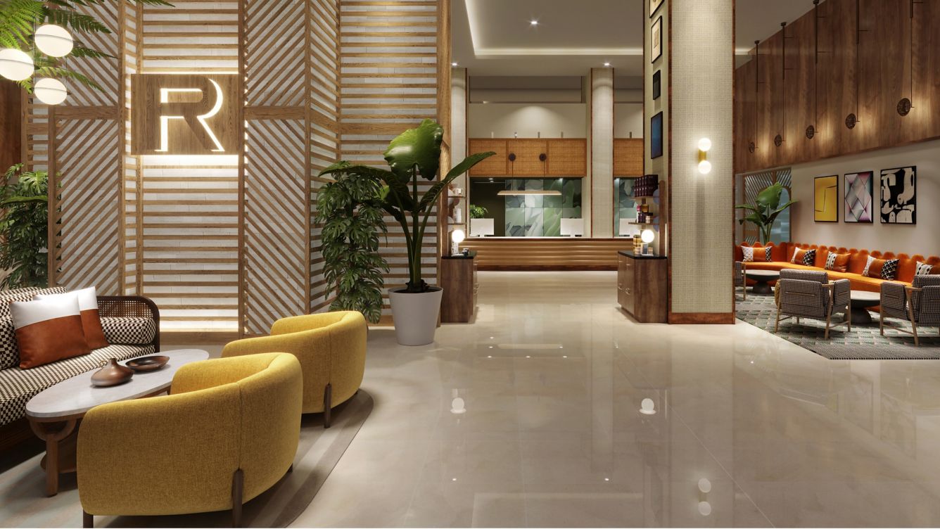 a lobby with a large plant and yellow chairs