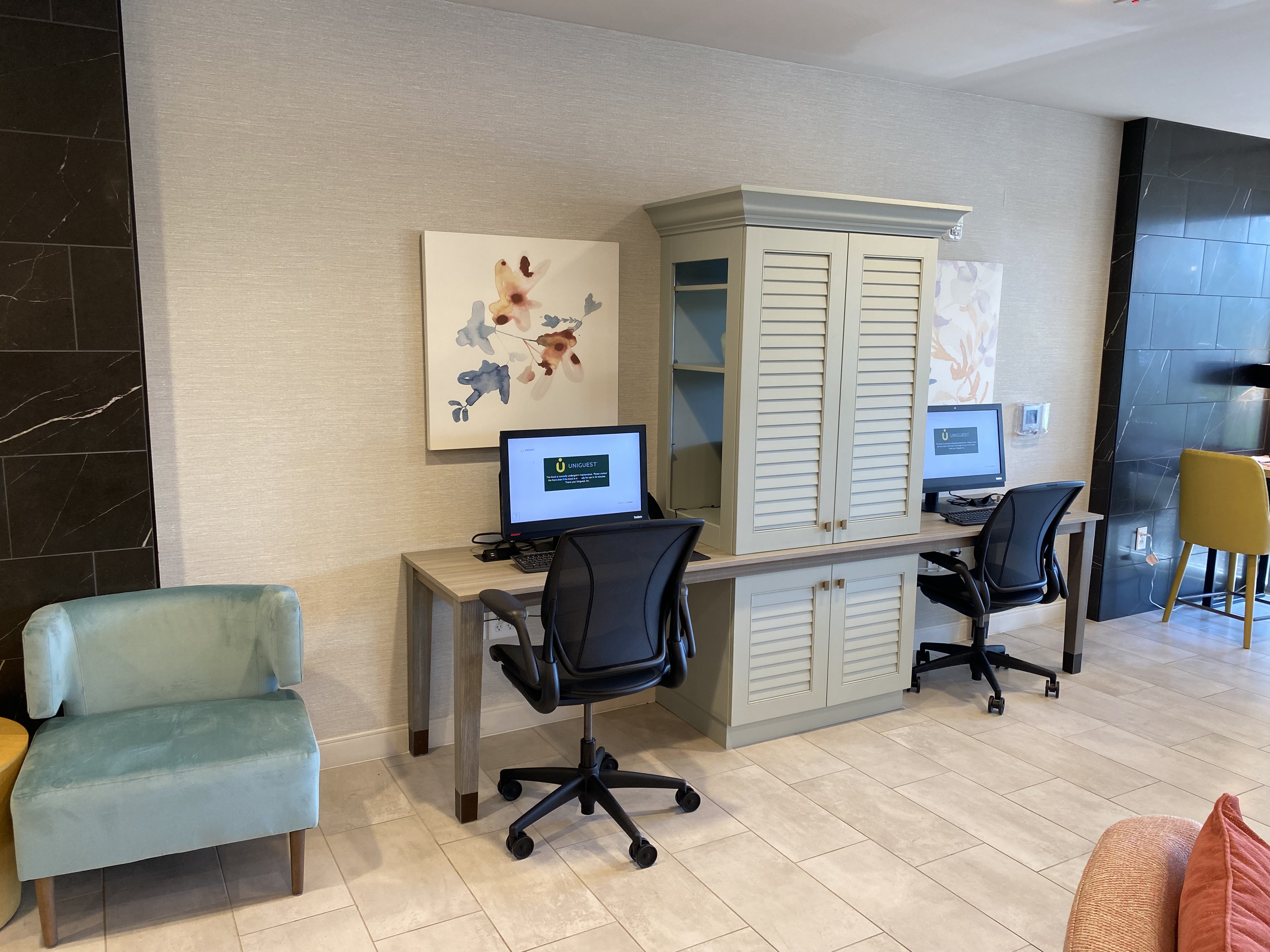 a room with a computer desk and chairs