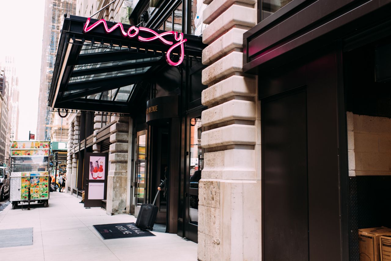 a store front with a pink neon sign