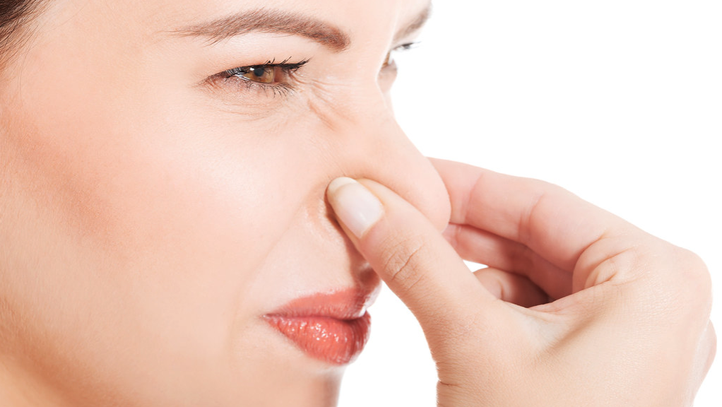 a close-up of a woman pinching her nose