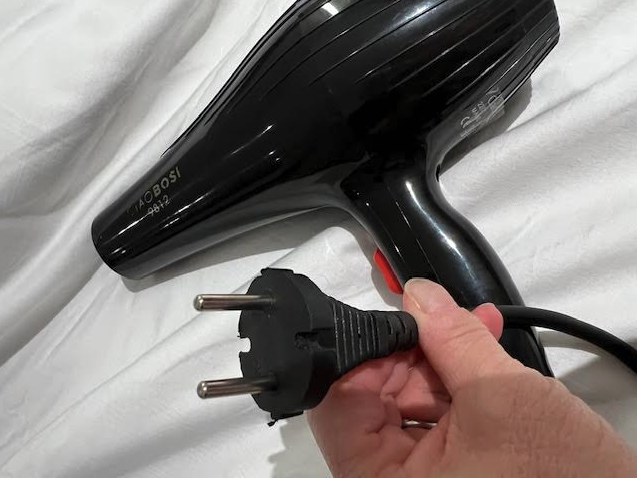 a hand holding a black hair dryer