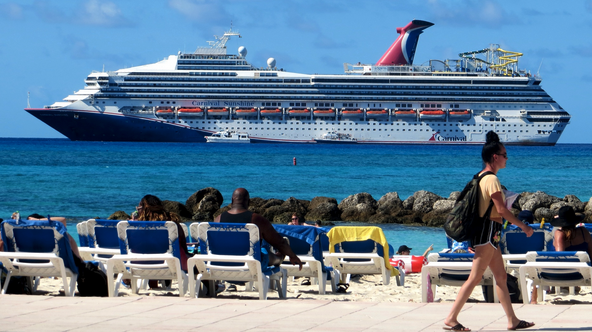 a group of people on a beach with a cruise ship in the background