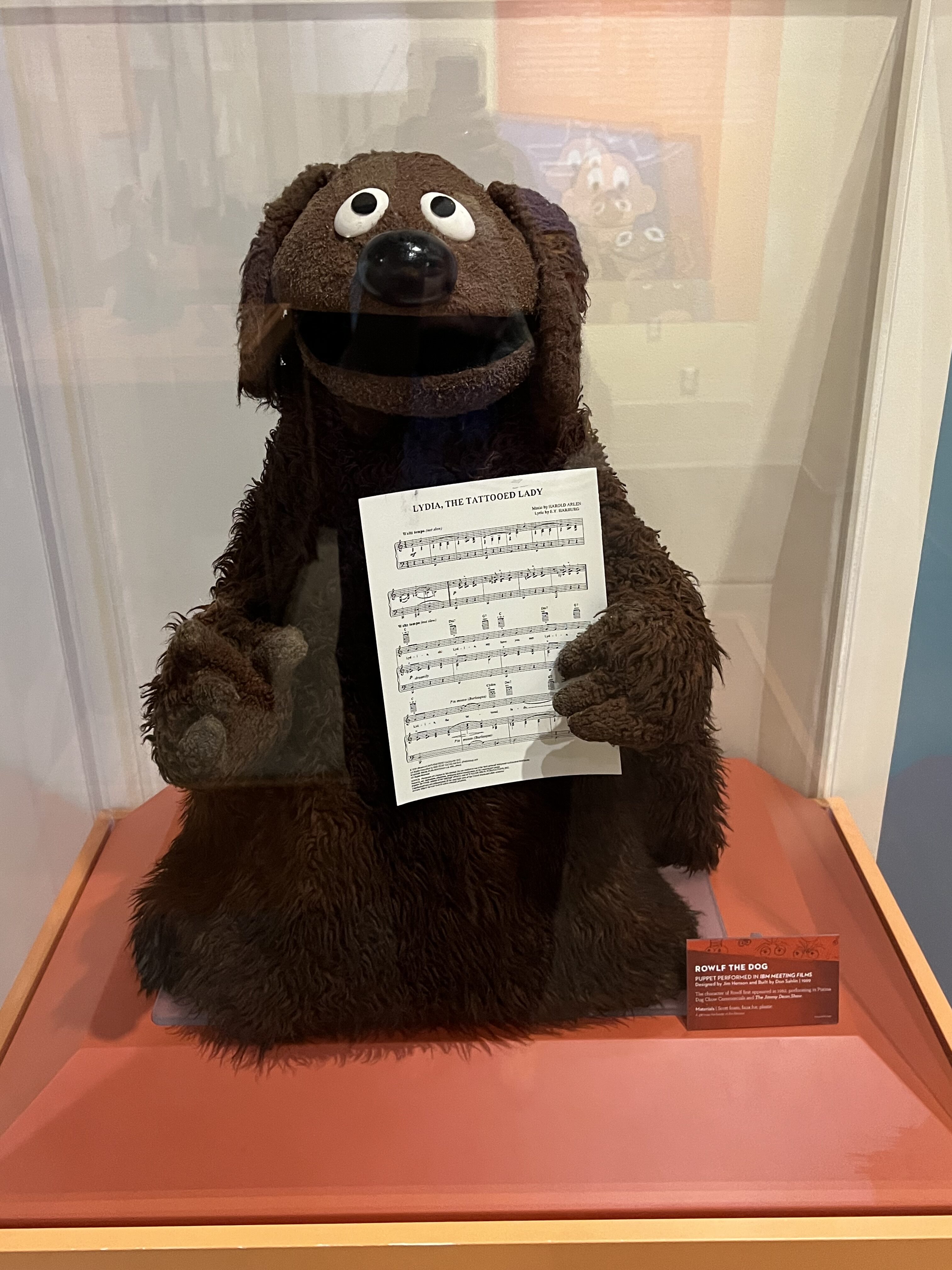 a stuffed animal holding a sheet of music