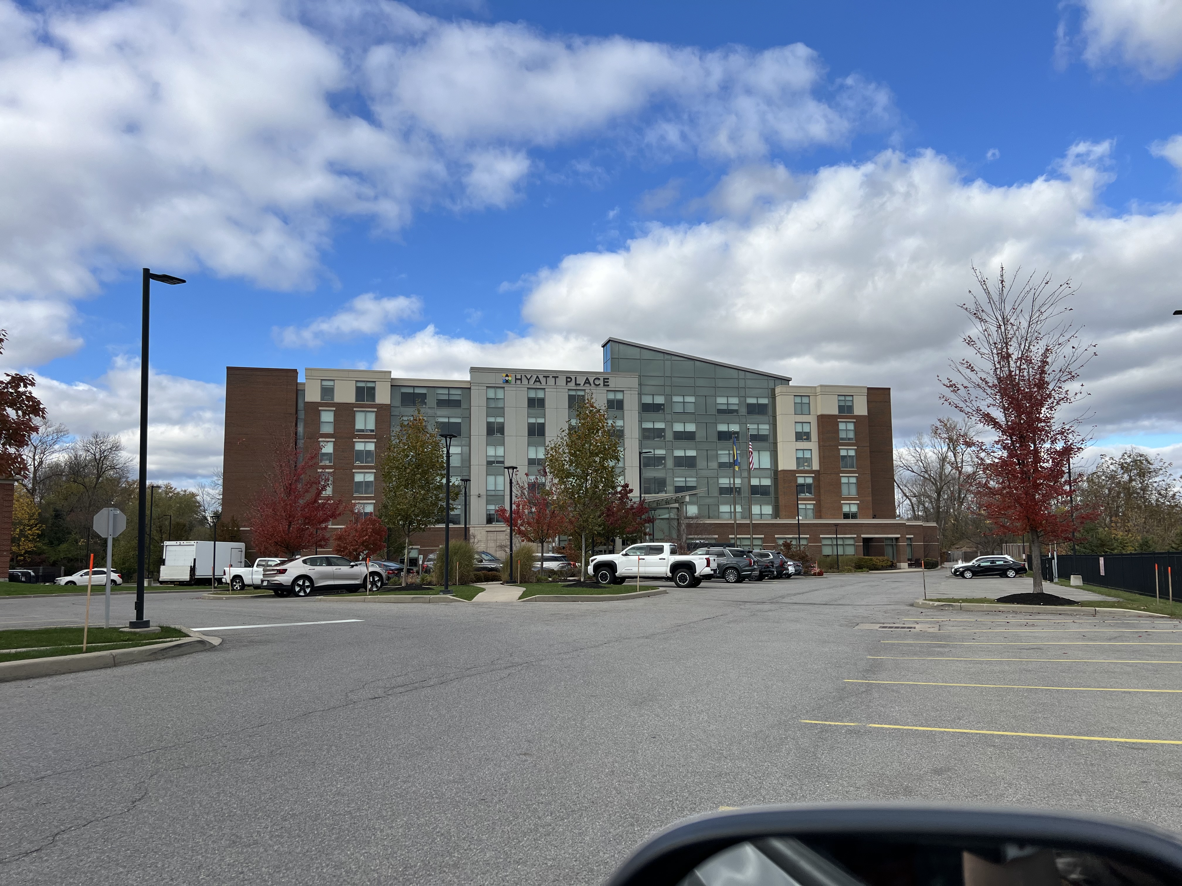 a parking lot with a building and cars in the background