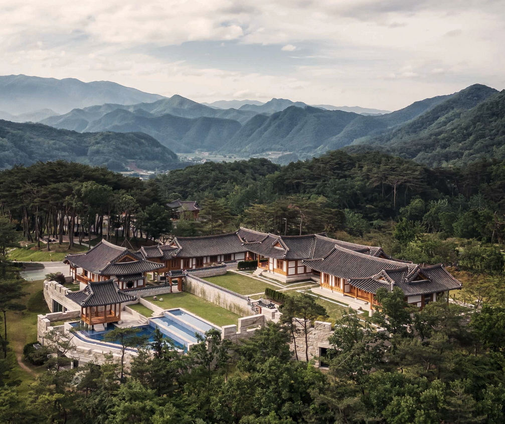 a building with a pool surrounded by trees