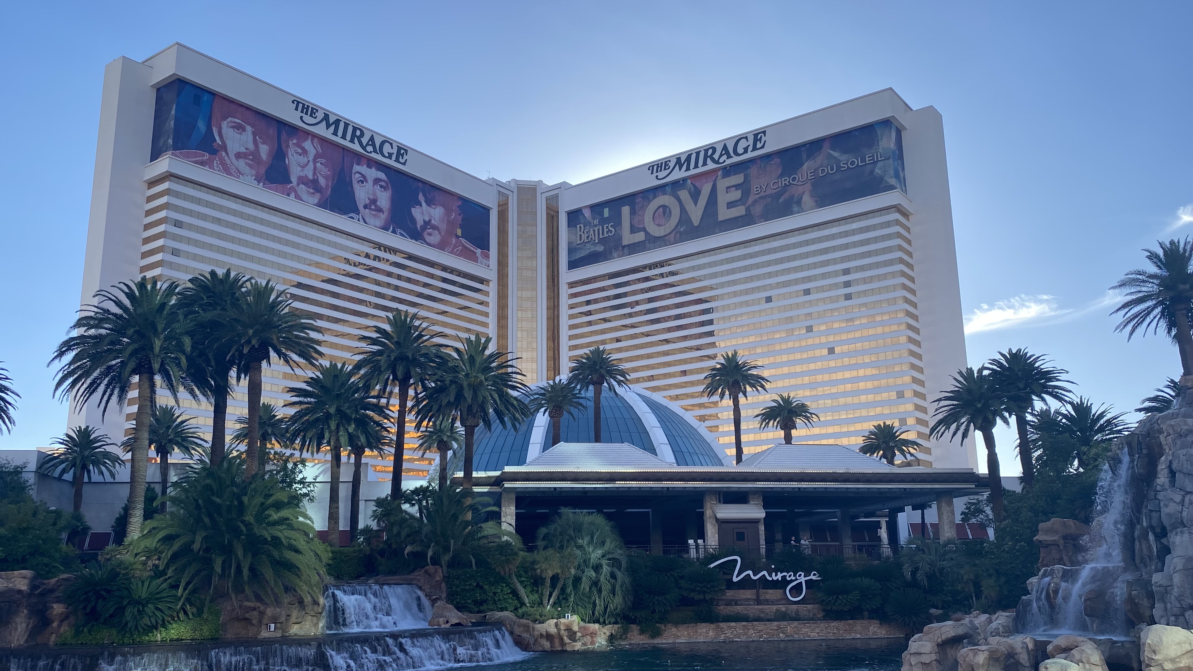 a large building with The Mirage and palm trees