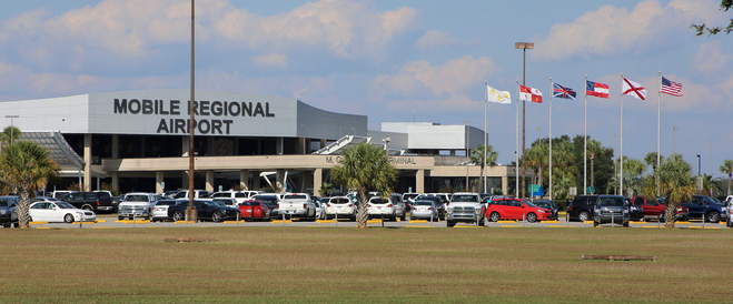 a parking lot with cars and flags in front of a building