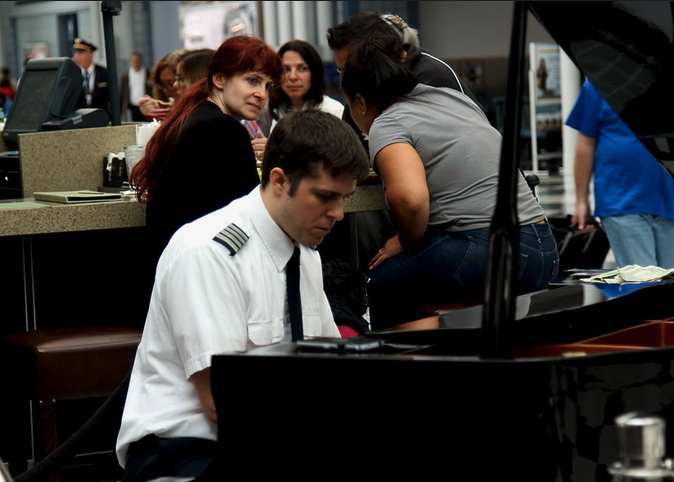 a man in a uniform sitting at a piano