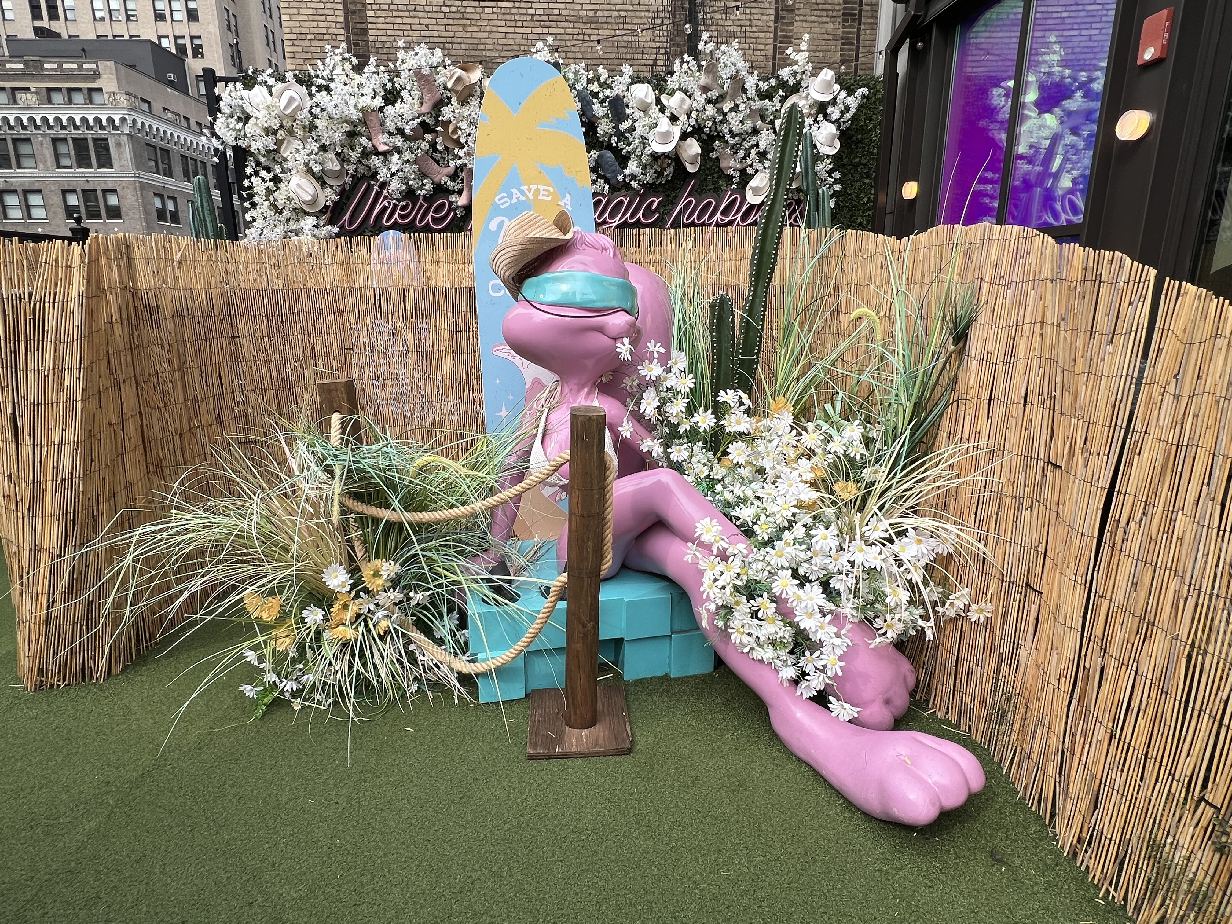 a statue of a purple animal with a hat and flowers