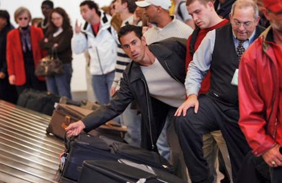 a group of people waiting for their luggage