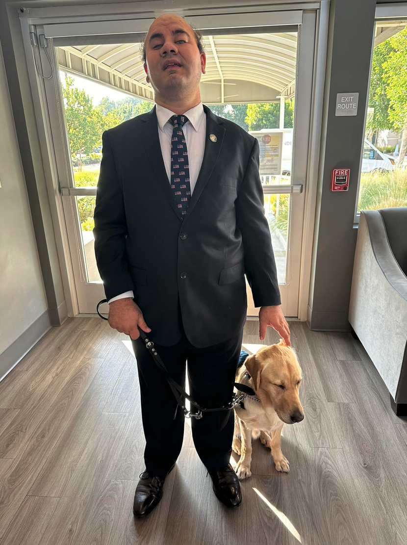 a man in a suit and tie standing next to a dog