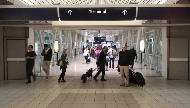 people in a terminal with people walking with luggage