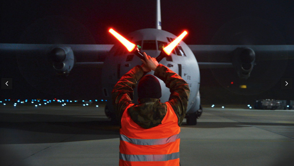 a man holding up a light sabers in front of a plane