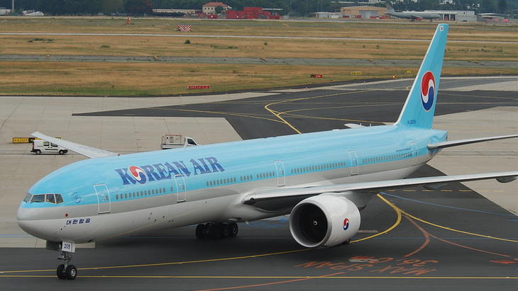 a blue and white airplane on a runway