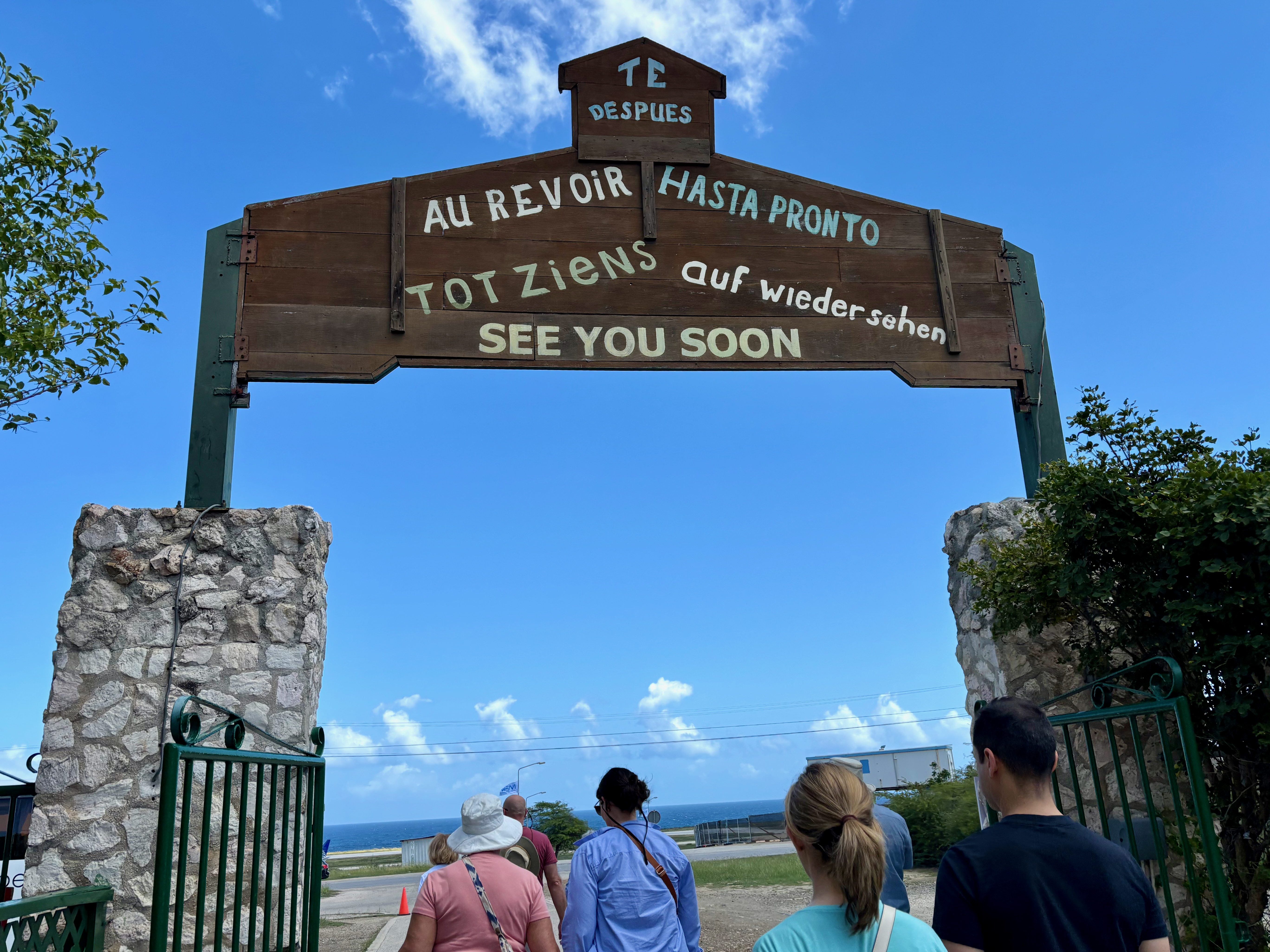 a group of people walking under a sign