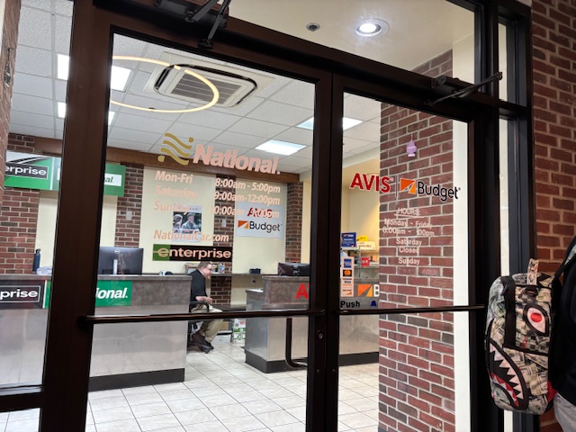 a glass door with a person standing in front of a brick building