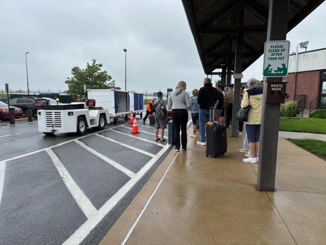 a group of people standing in a line at a bus stop