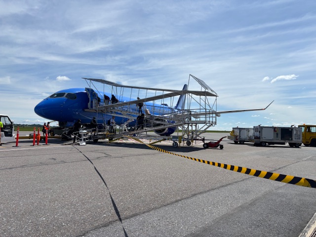 a blue airplane on a tarmac