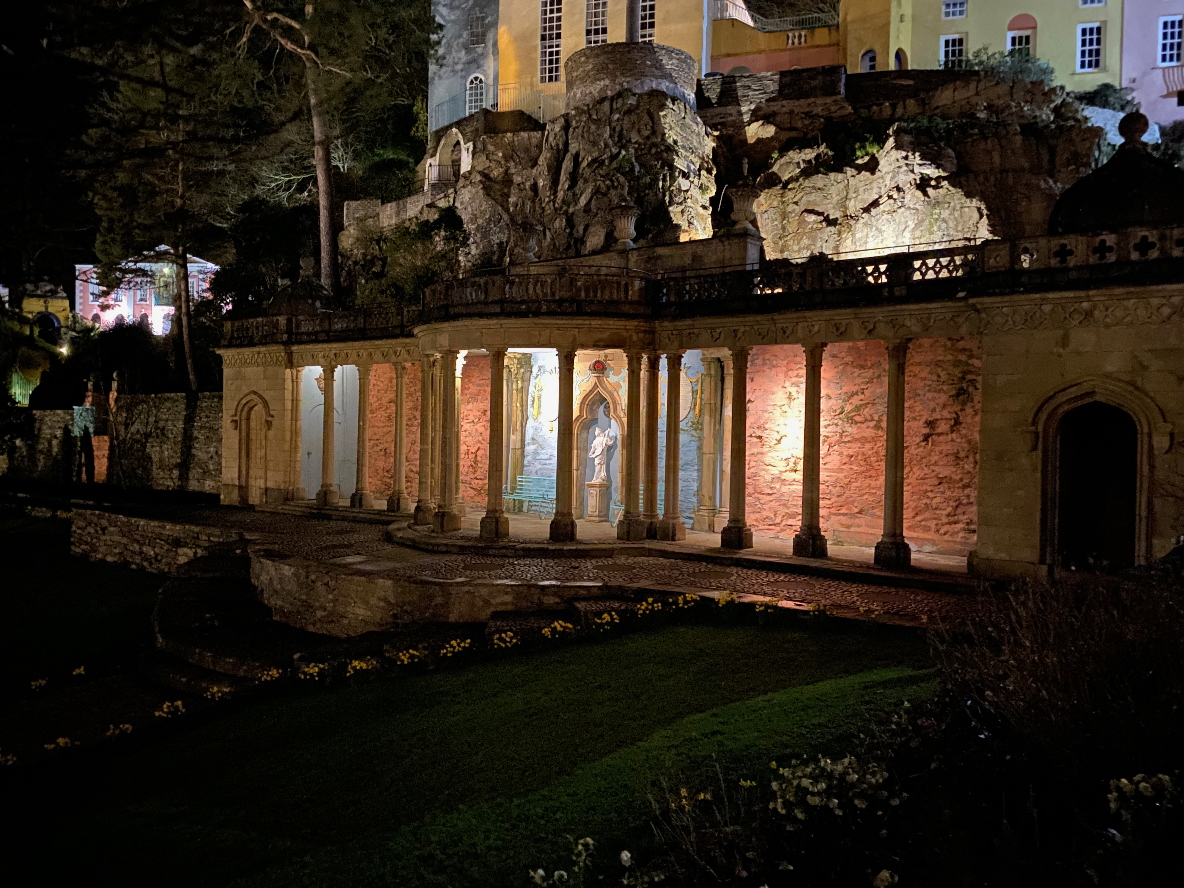 a stone building with columns and a stone wall