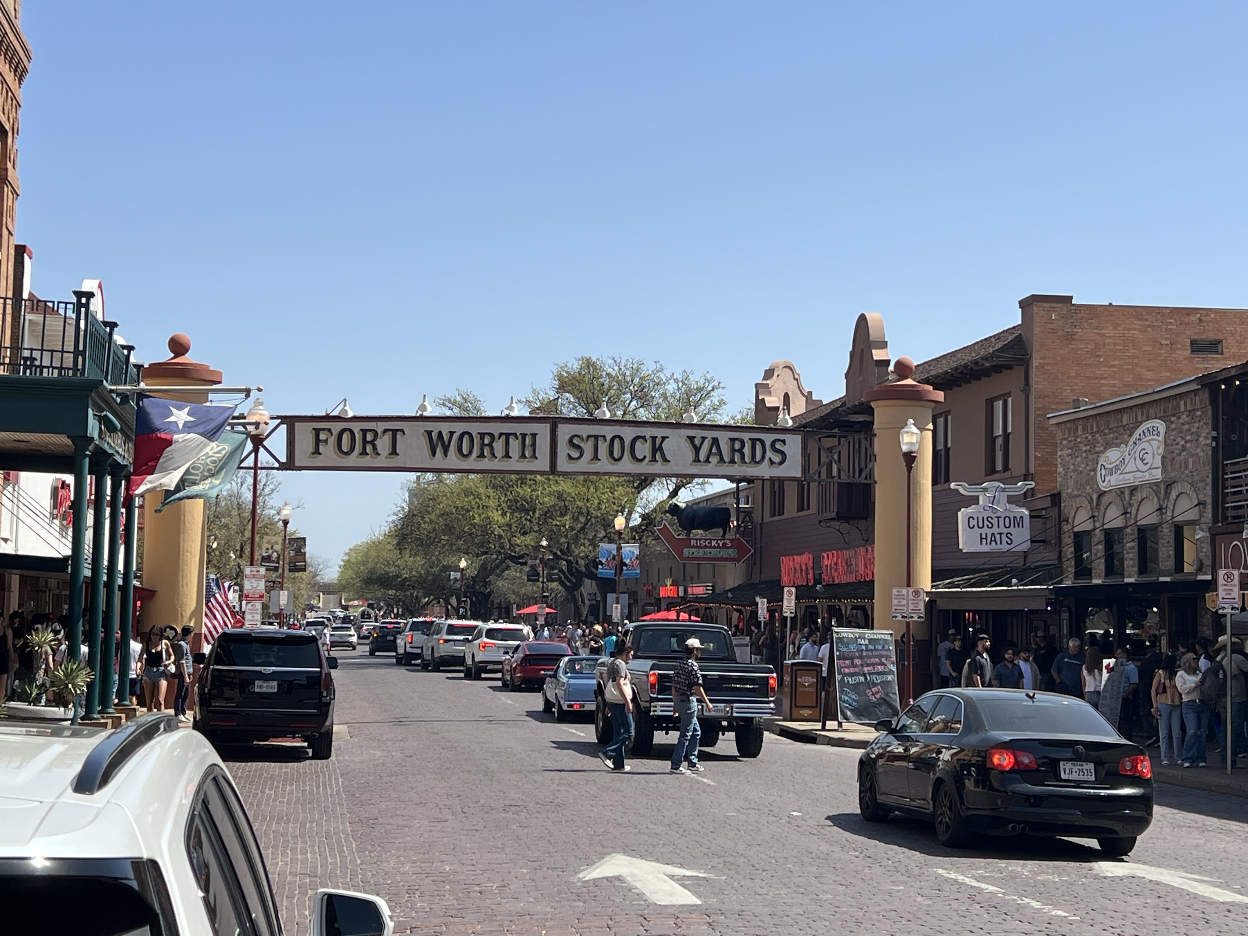 a street with cars and people walking on it