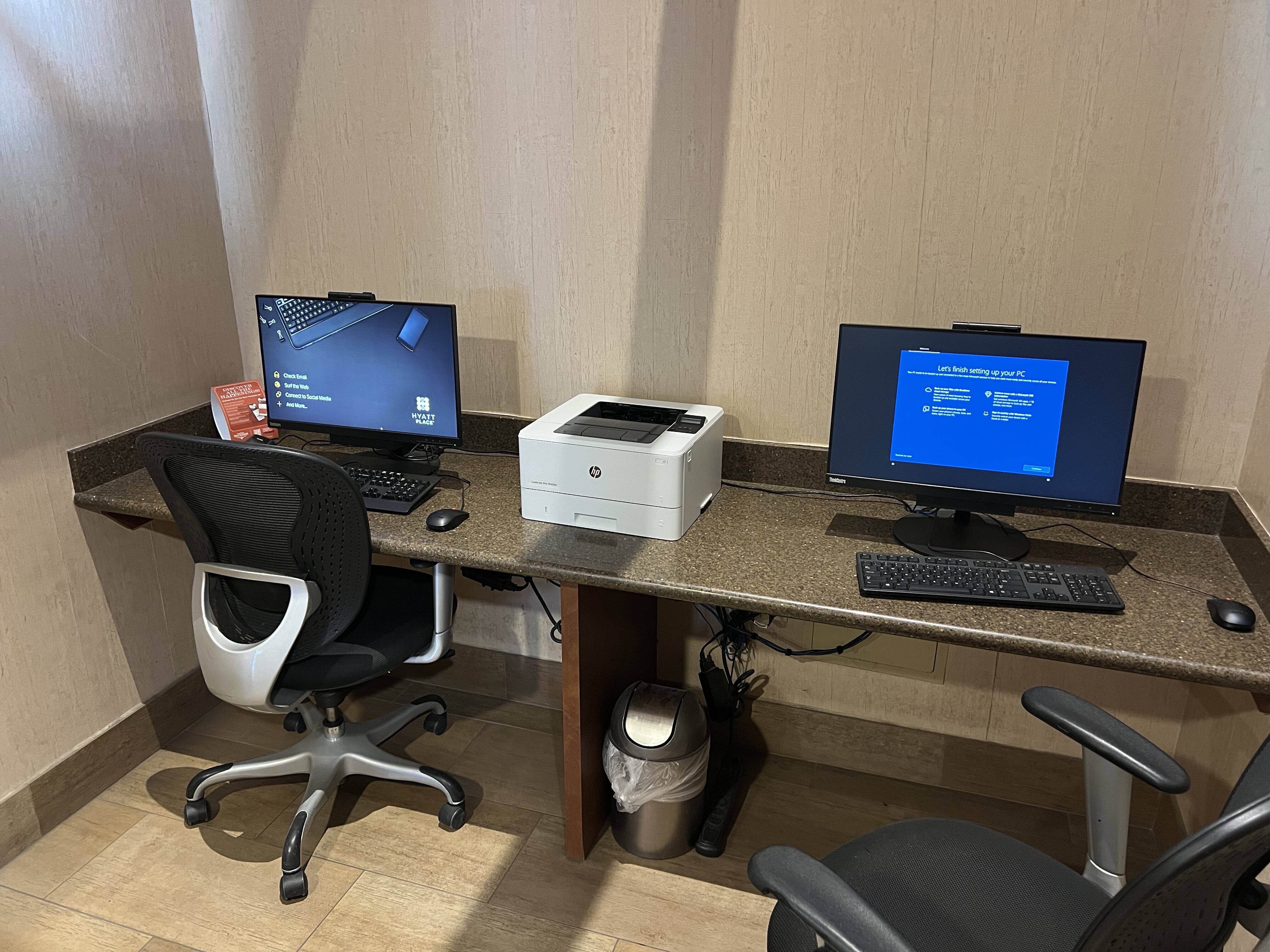 a desk with computers and a printer
