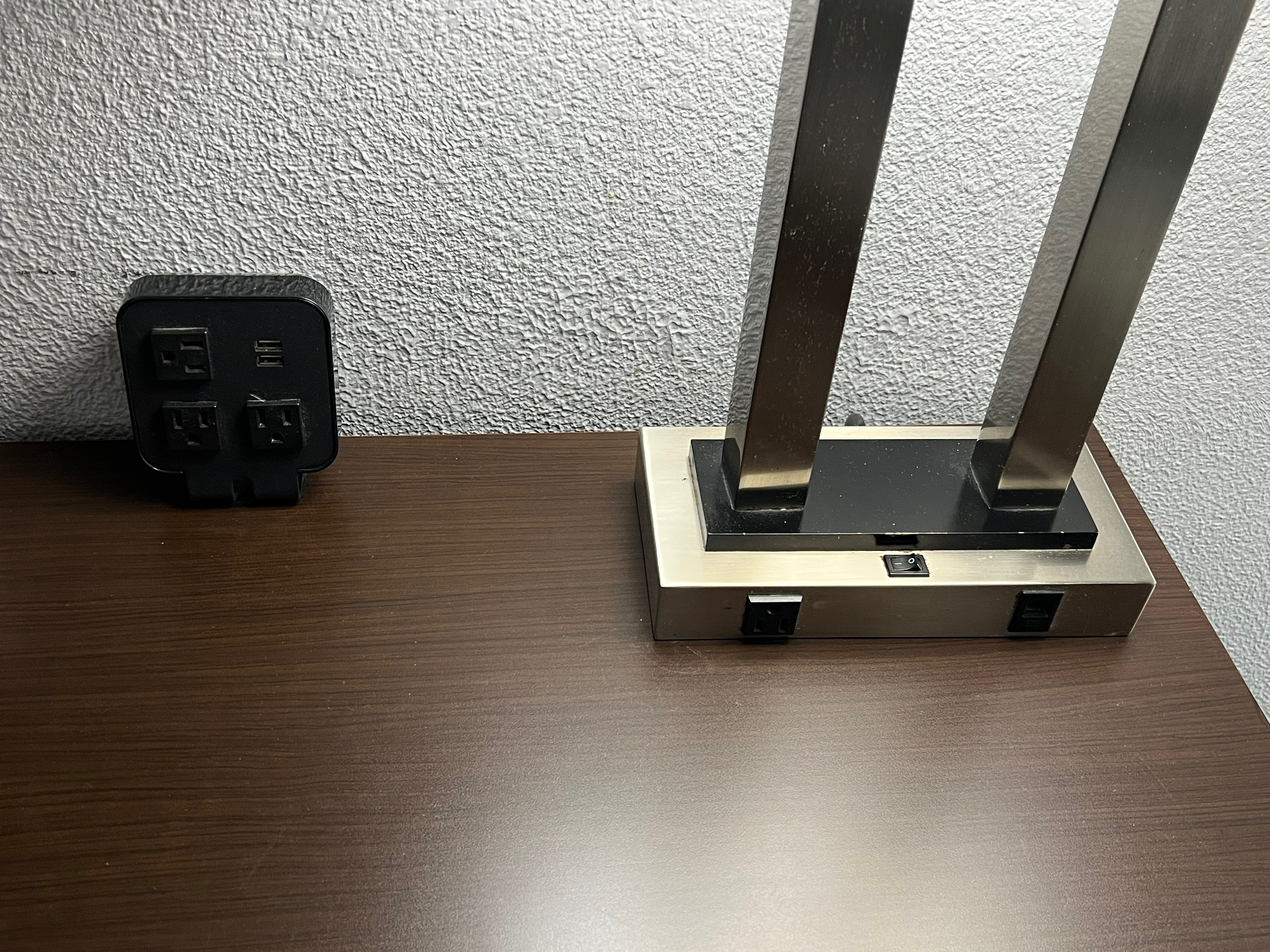 a black electrical outlet next to a metal stand