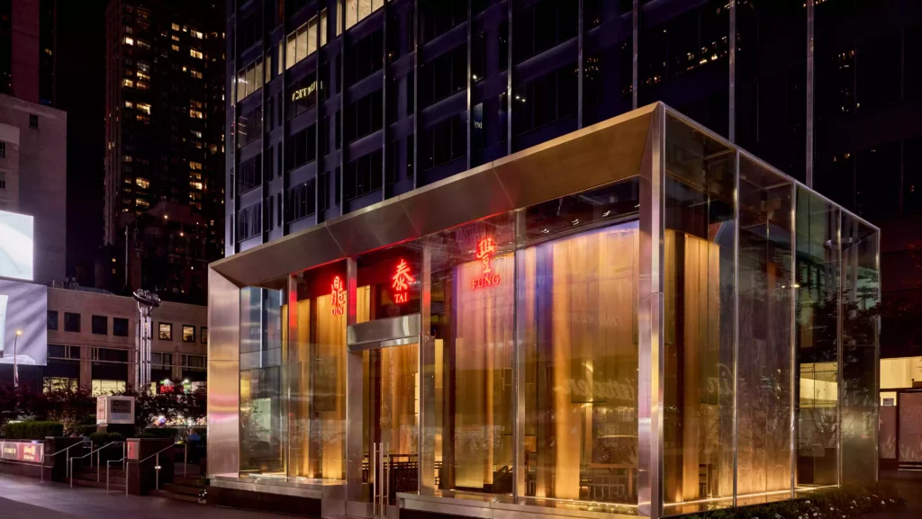 Exterior of Din Tai Fung Times Square location at night, lit with red neon signs and glass facade