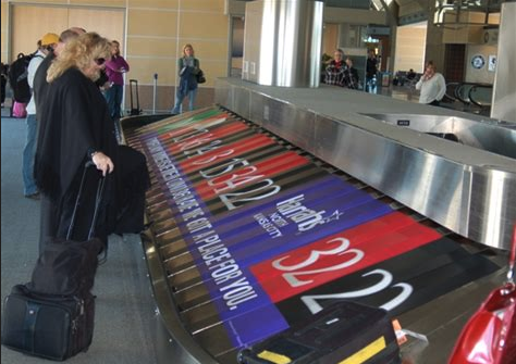 a woman looking at luggage on a conveyor belt