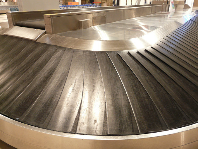 a metal conveyor belt with people in the background