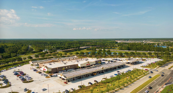 a large building with parking lot and trees